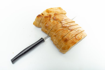 Slices of fresh bread and cutting knife on white background, isolated. Healthy proper nutrition.の写真素材