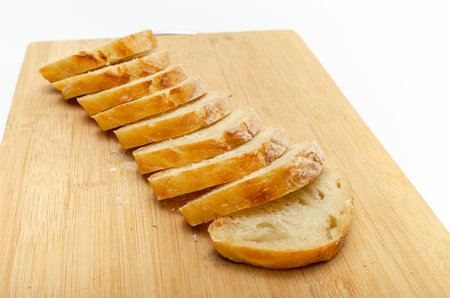 Sliced bread on wooden board. Isolated on white background, healthy food concept.