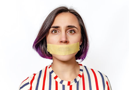 Woman's face with taped mouth. Concept of gender inequality and domestic violence. White background
