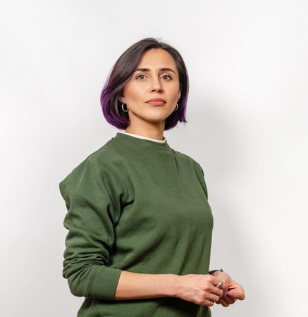 Portrait of Caucasian woman with dark purple hair in natural makeup and green sweater
