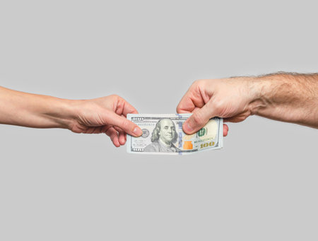 Male and women's hands keep dollars on gray background. Concept of investments, donations, charityの写真素材