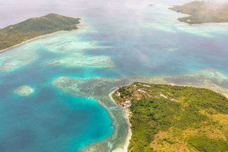 Fiji Islands. Turquoise waters of ocean wash island covered tropical vegetation. Travel concept