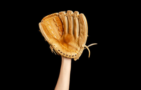 Baseball glove on woman's hand. Black background. Active sports, championship, victory, competitionの写真素材