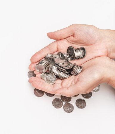 Female hands hold many silver coins in their palms
