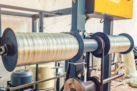 Bobbins of plastic wire in workshop. Spinning and winding of plastic coils of wire for constructionの写真素材