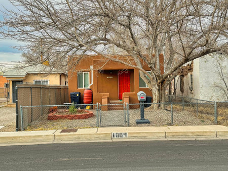 ALBUQUERQUE, NEW MEXICO, USA - March 9, 2023. Wooden mud houses. Wooden windows and doors. Tree near houseのeditorial素材