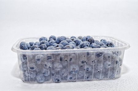 Transparent container with fresh blueberries. isolated on white. Side view Vitamins, immunityの写真素材