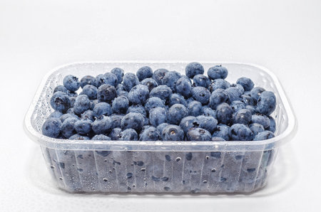 Transparent box with fresh blueberries isolated on white. Side view. Antioxidants, vitamins, healthの写真素材