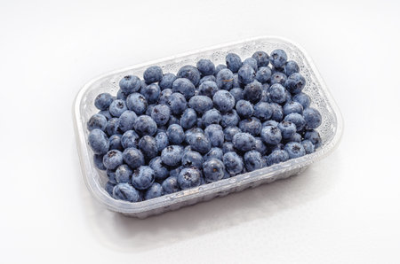 Top view transparent box with fresh blueberries isolated on white. Antioxidants, vitamins, healthの写真素材