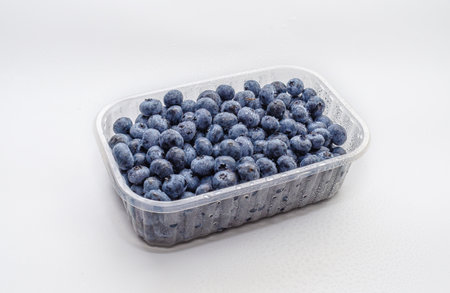 Transparent container with fresh blueberries. Isolated on white. Studio light. Vitamins, immunityの写真素材
