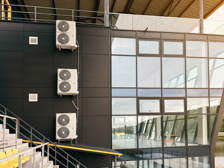 Air conditioning units on the side of a modern steel-framed buildingの写真素材