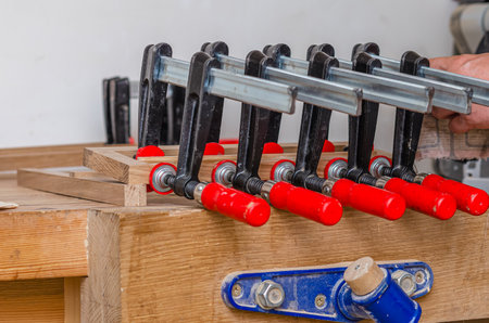 Clamps are fixed on a wooden frame, gluing of wooden boardsの写真素材