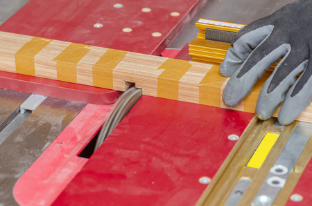 Circular saw cuts grooves in a board in a carpentry workshopの写真素材