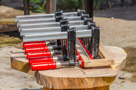 Clamps are fixed on a wooden frame, gluing of wooden boardsの写真素材