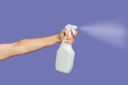 Cleaning, sprayer and hand for hygiene, disinfection. Cleaning equipment. Blue backgroundの写真素材