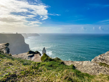 Rocky shore of the ocean. Blue water beyond horizon. Coast of Irelandの写真素材