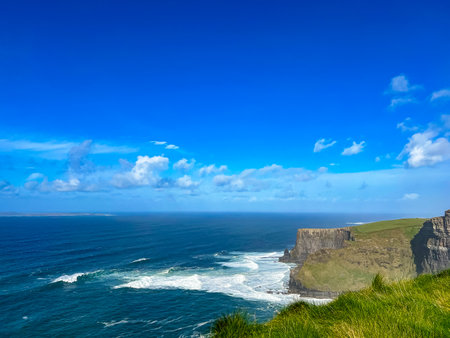 Dramatic Irish rocky shoreline with vast ocean beyond the horizon, blue waters meet rugged coast of Ireland, peaceful natural beautyの写真素材