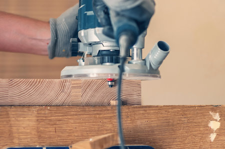Hand router in action, finishing wooden board edges with expert craftsmanshipの写真素材