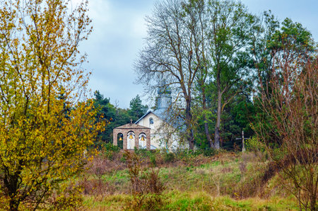Small church with bell tower among autumn trees. Autumn landscape with church and forest. Travelの写真素材