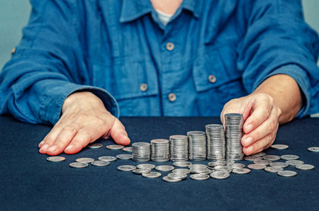 Concept of business, counting and saving money. Female hand holding column of coins. Donationの写真素材
