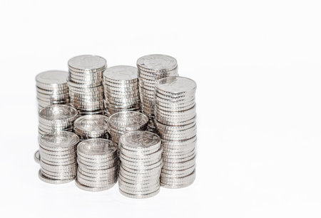 Detailed view columns of silver coins. Isolated on white. Idea of business and finance. Copy spaceの写真素材
