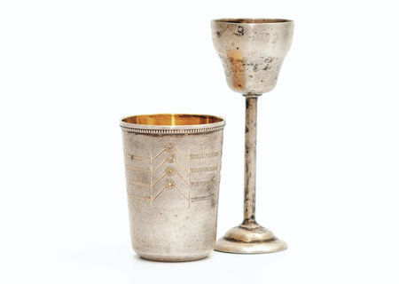 Small silver gilded antique glass and goblet on high stem with engraving pattern. White backgroundの写真素材