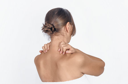 Neck pain, woman in towel, isolated on white background, studio shot. Rear view. Health conceptの写真素材