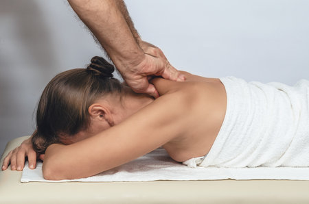 Collar zone massage for woman. Strong male hands of masseur close-up. Neck and collar zone massageの写真素材