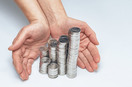 Palms protect columns of silver coins. Finance and banking concept. Savings protection, insurance