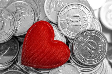 Red heart in middle of background of coins. Money for travel, jewelry, pleasure or charity. Valentine's Dayの写真素材