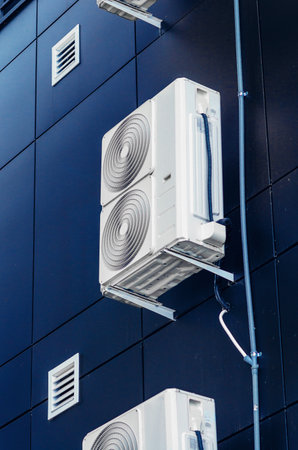 White air conditioner on the wall of a modern building. Ventilation of premisesの写真素材