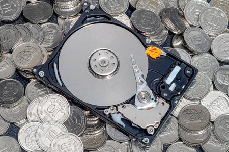 Top view of open top hard drive on pile of coins. Concept of virtual money mining on hard drive farm