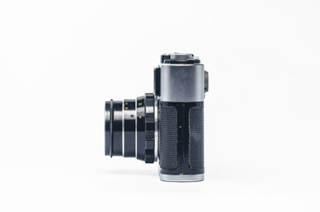Side view of vintage silver film camera with black leather on white background