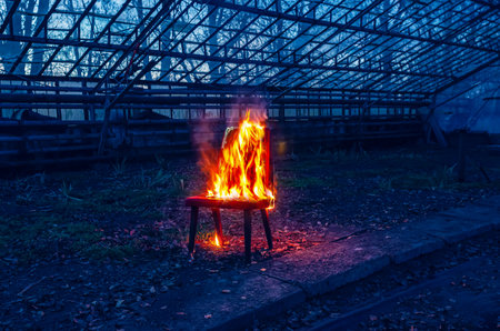 Wooden chair is on fire. Incineration of furniture. Conceptual photo, burnoutの写真素材