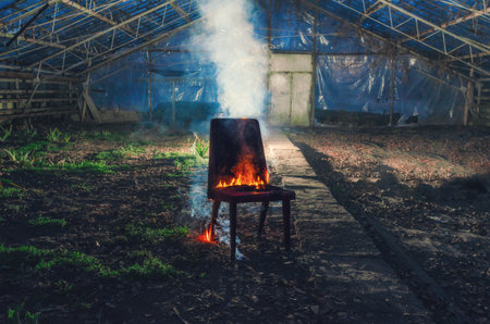 Wooden chair is on fire. Incineration of furniture. Conceptual photo, burnout.の写真素材