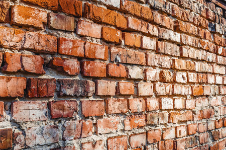 Old brickwork, side view. Defects in the brick wall. Flat view, close-up. Brick background