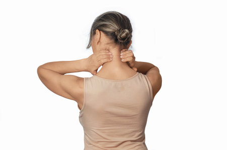 Neck pain prevention. Self-massage of neck muscles, woman in beige T-shirt, isolated on white. Side viewの写真素材