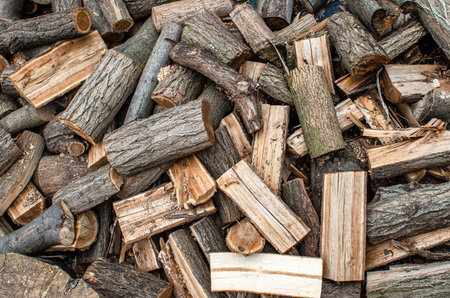 Scattered pile of chopped firewood. Stacking firewood. Chopped firewood for winter. Abstract background of chopped logsの写真素材