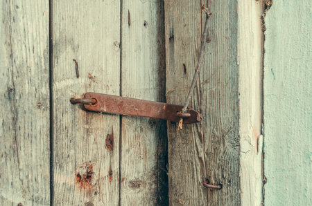 Part of old dry wooden door with iron lock of abandoned building. Concept of old abandoned houses in countrysideの写真素材