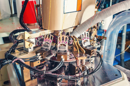 Close-up photo of machine in workshop with exhausted pipe on industrial knitting machine. Knitting...
