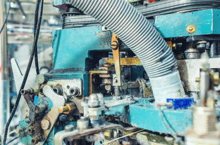 Exhaust pipe on industrial knitting machine. Close-up. Mechanisms of knitting factory. Production of...