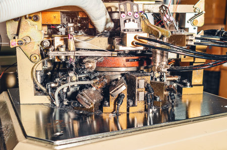 Lots of dust from threads. Image of sock knitting machine in operation. Machinery and equipment in...