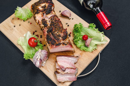 Set of wine, pork belly, vegetables, spices. On wooden board - baked sliced pork belly, served with vegetables and spices. Set of products for dinner. Restaurant menu.の写真素材
