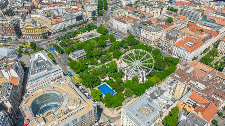 Elizabeth Square (Erzsebet ter), Budapest, Hungary. Aerial view of the Budapest Ferris Wheel (Budapest Eye), surrounded by buildings and greenery. Tourist attractions.の写真素材