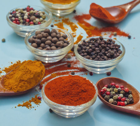 Spices and seasonings. Orange paprika in bowl on light blue background. Texture of food seasonings close-up. Vibe of spices in cooking.の写真素材