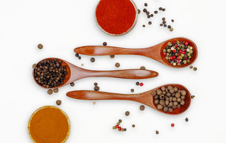 Assortment with various aromatic spices and seasonings in transparent small bowls and wooden spoons on white background.の写真素材