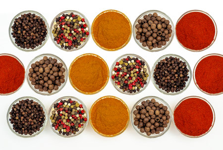Flat lay of spice composition. Interesting composition with various aromatic spices and seasonings in small transparent bowls on white background. Use for website, content splash for cooking.の写真素材
