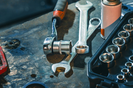 Repair mechanisms background on table with set of socket wrenches, can of glue. Professional set of...