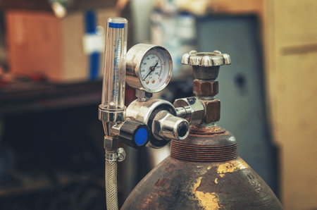 Gas cylinder pressure gauge. Valve on oxygen cylinder. Cylinder with compressed gas for oxygen, nitrogen, hydrogen, carbon dioxide and argon for welding. Technological photo.の写真素材