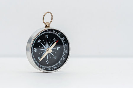 Vintage compass with black dial isolated on white background. Navigation device with arrows...